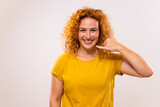 Portrait of happy ginger woman  showing call me gesture.