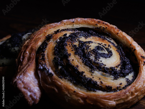 Two delicious buns with poppy seeds lie on a wooden background. photo