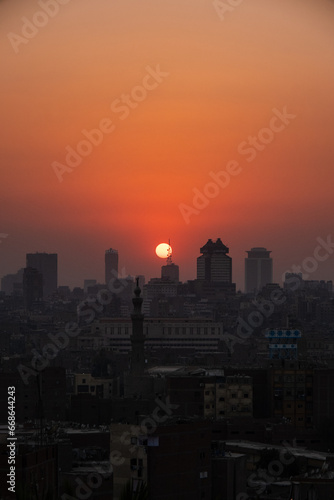 Orange and yellow open skies. Sunset over the city of Cairo in Egypt. Silhouette of the buildings in the metropolis. Neighborhood view of the cityscape.