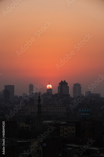 Orange and yellow open skies. Sunset over the city of Cairo in Egypt. Silhouette of the buildings in the metropolis. Neighborhood view of the cityscape.