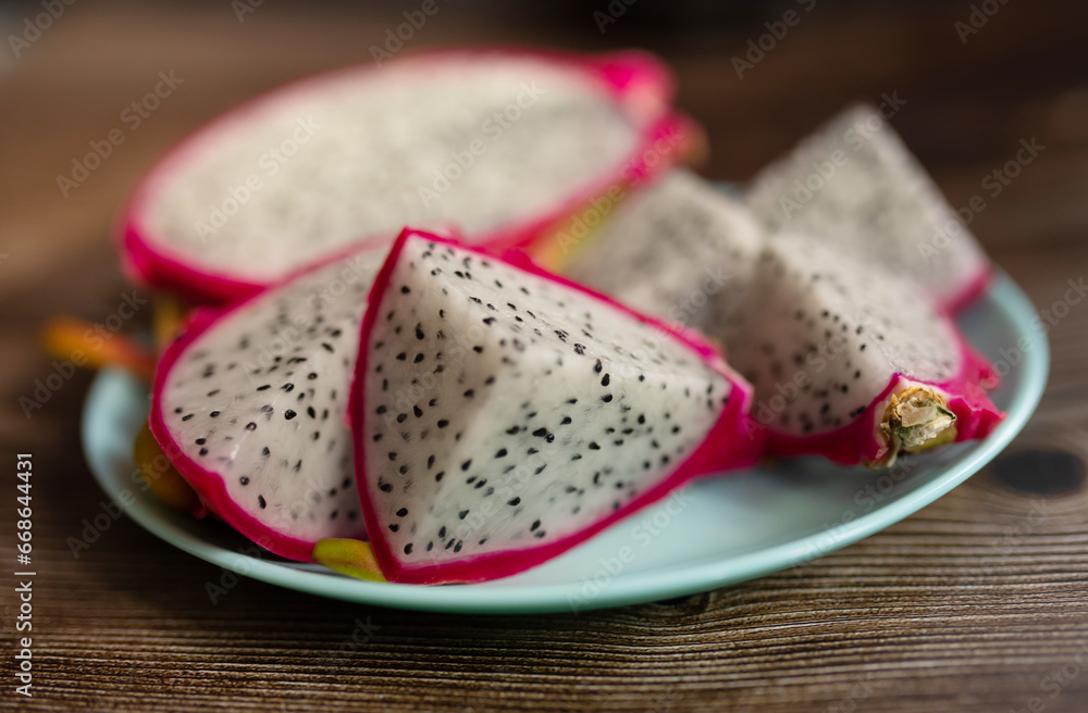 Red dragon fruit or pitahaya on plate on wooden background, Tropical fruit in summer season. Red dragon fruit or pitahaya on plate on wooden background, Tropical fruit in summer season.