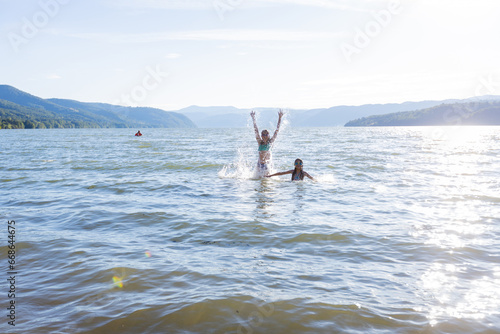 Happy summertime, children enjoying water fun on sunny summer vacation.