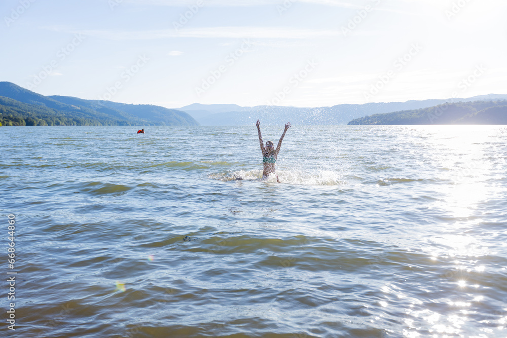 Summertime, child enjoying water fun on sunny summer vacation.