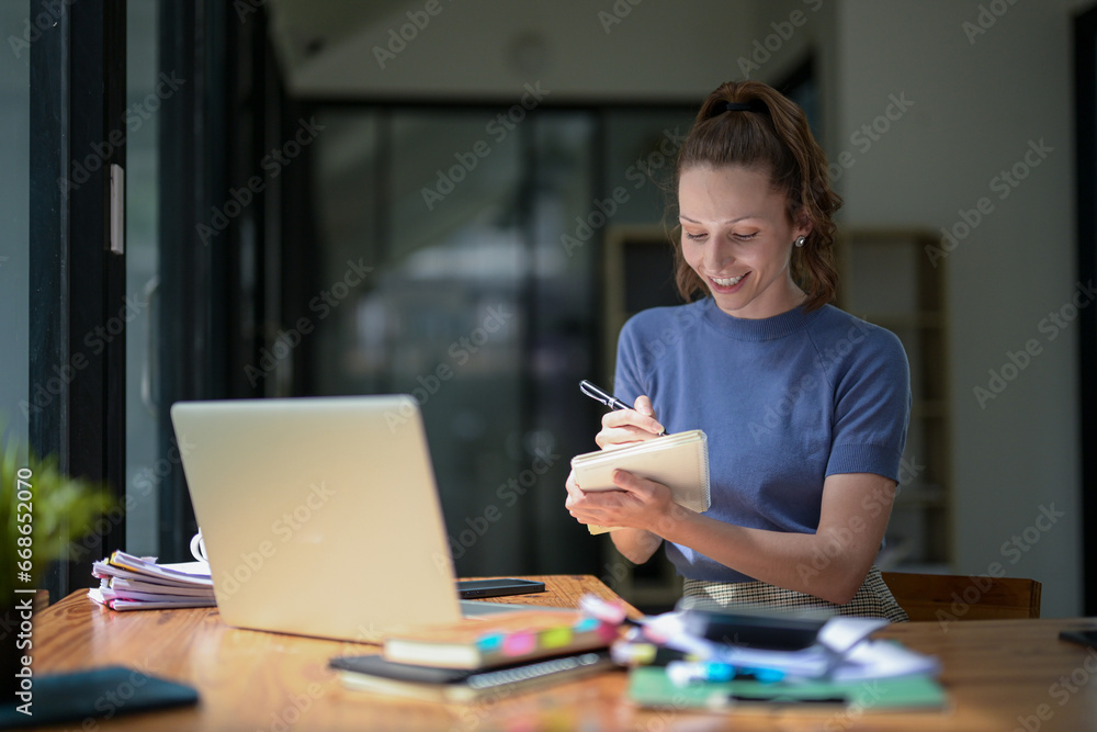 Businesswoman remotely meeting with team using laptop to discuss and write collaborative plans. Businesswoman remotely meeting with team using laptop to discuss and write collaborative plans.