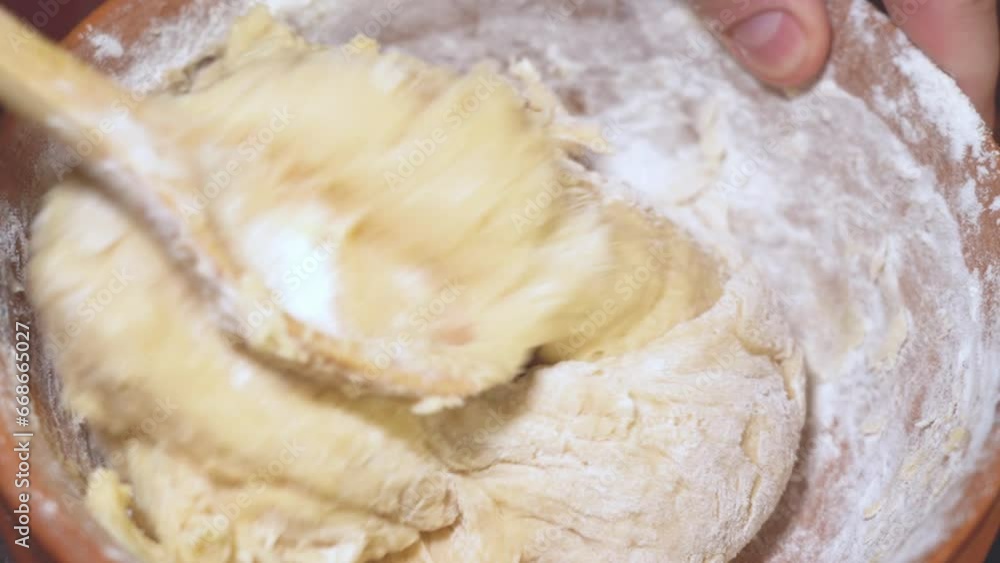 Rustic spoon whips egg yolk and flour in a bowl close up view
Rustic spoon whips egg yolk and flour in a bowl close up view
