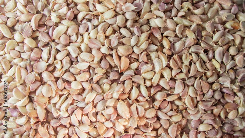 Naklejka premium Lots of garlic with purple skin on a white crate background
