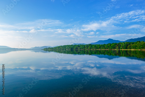 青空を鏡の湖面に反射する湖。北海道の屈斜路湖。