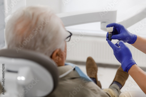 Oral care treatment for a old man patient came for a visit to the dentist he laying down on the dentist chair and have a checkup the doctor using medical instruments for treatment