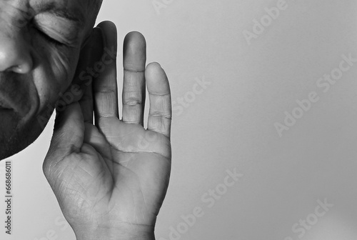 deaf man suffering from deafness and hearing loss on grey black background with people stock image stock photo	 photo