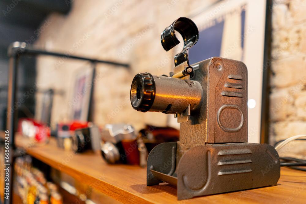 A rare antique projection device for broadcasting films stands on wooden shelf in an antiques store