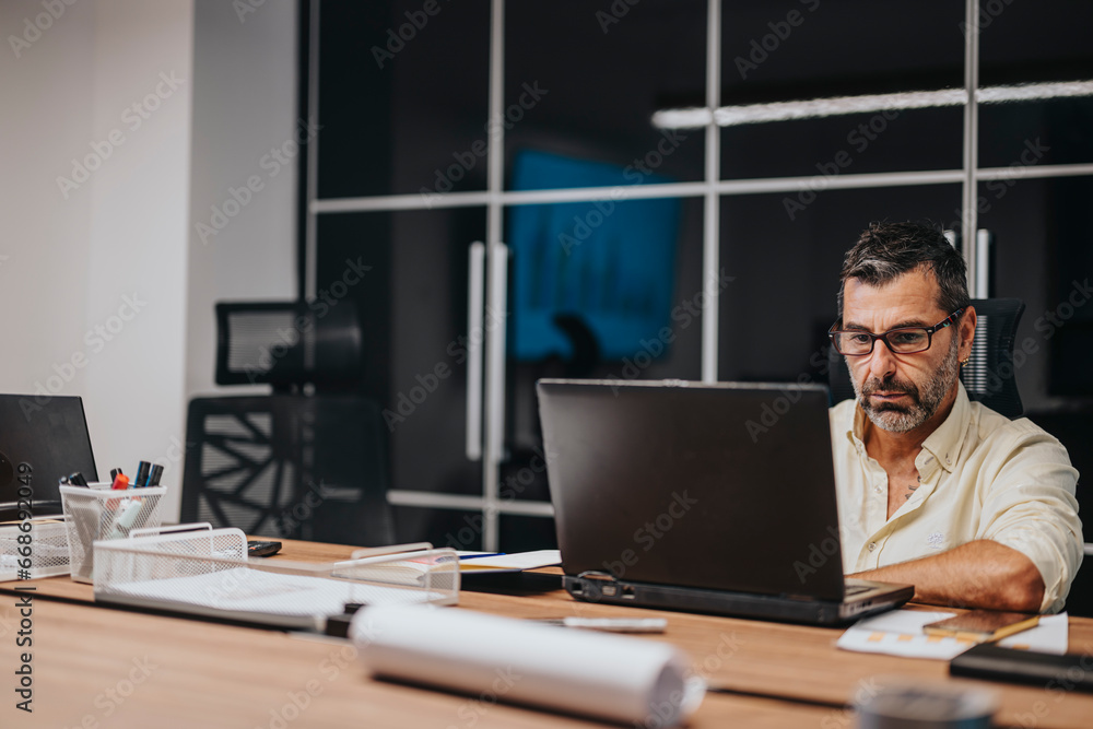 Multicultural professionals discussing architectural blueprints in boardroom meeting. Successful teamwork and collaboration in a diverse office environment. Multicultural professionals discussing architectural blueprints in boardroom meeting. Successful teamwork and collaboration in a diverse office environment.