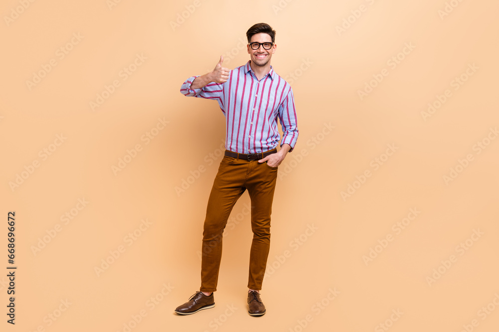 Full length photo of cheerful attractive man dressed stylish clothes thumb up cool job nice feedback isolated on beige color background Full length photo of cheerful attractive man dressed stylish clothes thumb up cool job nice feedback isolated on beige color background