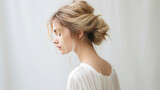 Messy dreamy low bun hairstyle for woman. Female hairstyle free bun, copy space.