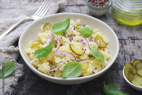 Smashed potato salad with pickles, red onion, basil and olive oil