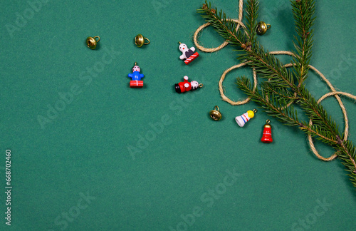 Christmas and New Year tree branch and craft toys on green background. Top view of christmas minimalist decorations