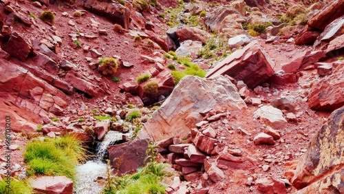 Les gorges tizi N'Ghougoult Atlas maroc, avec des rochers et sa terre rouge, sa peu de végétation, ruisseau d'eau, parcours sportif, beauté naturelle, exploration à l'inconnu, pente raide de montagne, photo