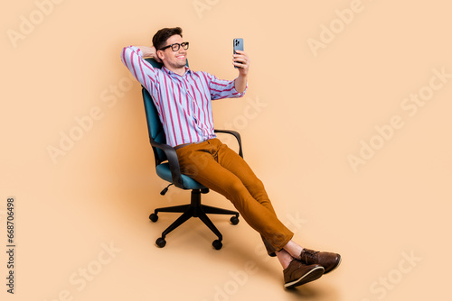 Photo of attractive nice man boss chief sitting armchair speaking online video meeting wifi connection isolated on beige color background