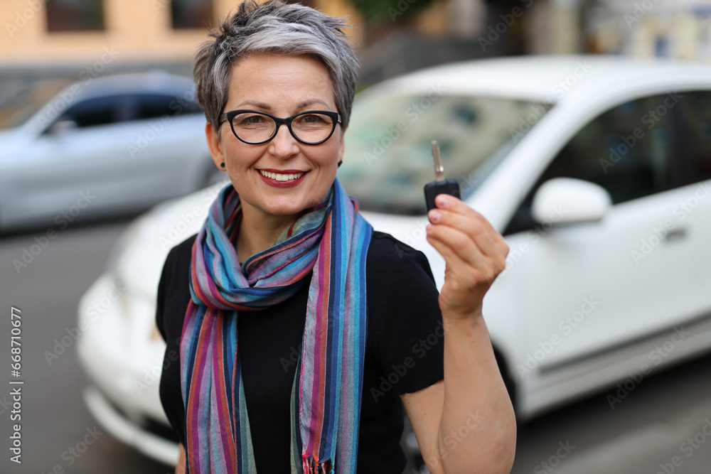 Φωτογραφία Smiling woman holds car keys, a symbol of her successful business rental, bringi