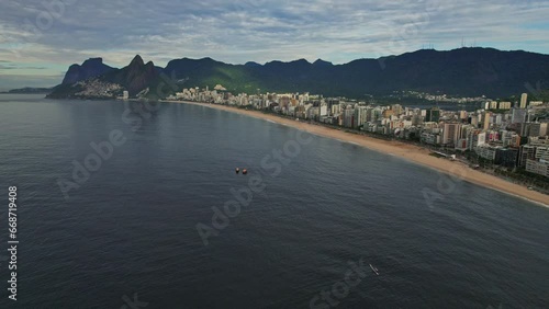 Drone Footage of Ipanema Beach in Rio De Janeiro in Brazil. The video is a 180 degree apnorama of the ipanema beach with boats as a subject for the orbit.