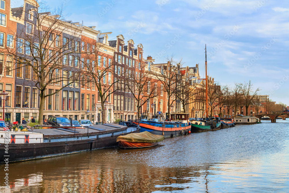 Cityscape on a sunny winter day - view of the water canal in the historic center of Amsterdam, the Netherlands