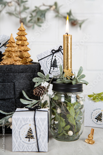 Weihnachtsgeschenke mit Kerze, Bäumen, Zweigen in den Farben schwarz gold natur