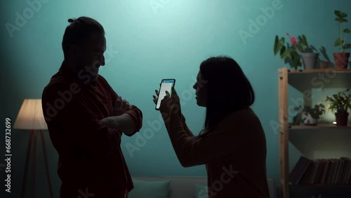 Conflict, quarrel and jealousy concept. Young couple, woman jealous, takes the smartphone from her husband, demands an explanation