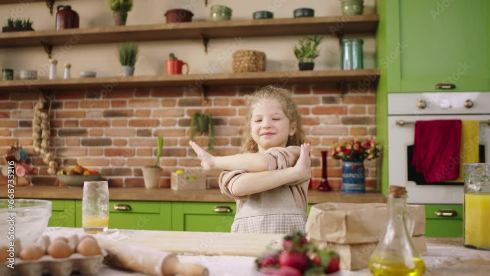 Rustic kitchen island pretty and smiling large very excited little girl dancing while preparing some dessert at the kitchen island at home Rustic kitchen island pretty and smiling large very excited little girl dancing while preparing some dessert at the kitchen island at home