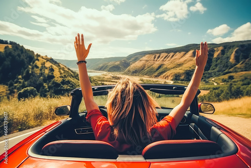 Two girls in red car driving with their hands up. Freedom concept and traveling escape.