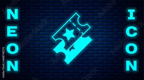 Glowing neon Cinema ticket icon isolated on brick wall background. Vector