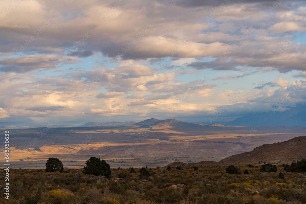Cloudy picturesque Sunrise in Owens Valley. Golden lighting and plants during fall in the Buttermilks at the foothills of the Sierra Nevada Mountains.