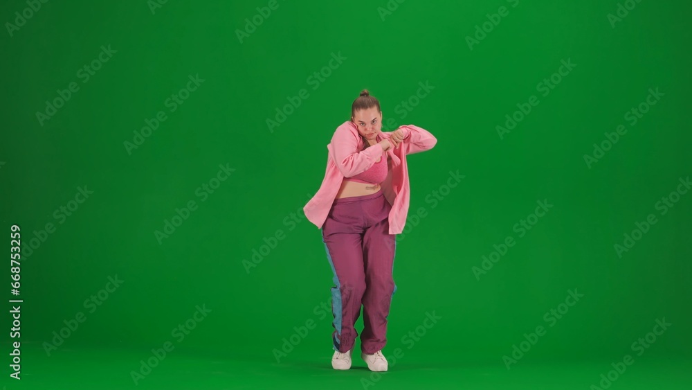 Attractive woman dancing jazz-funk on green screen chroma key background in a studio. Modern dynamic and energetic dance choreography. Full length.
