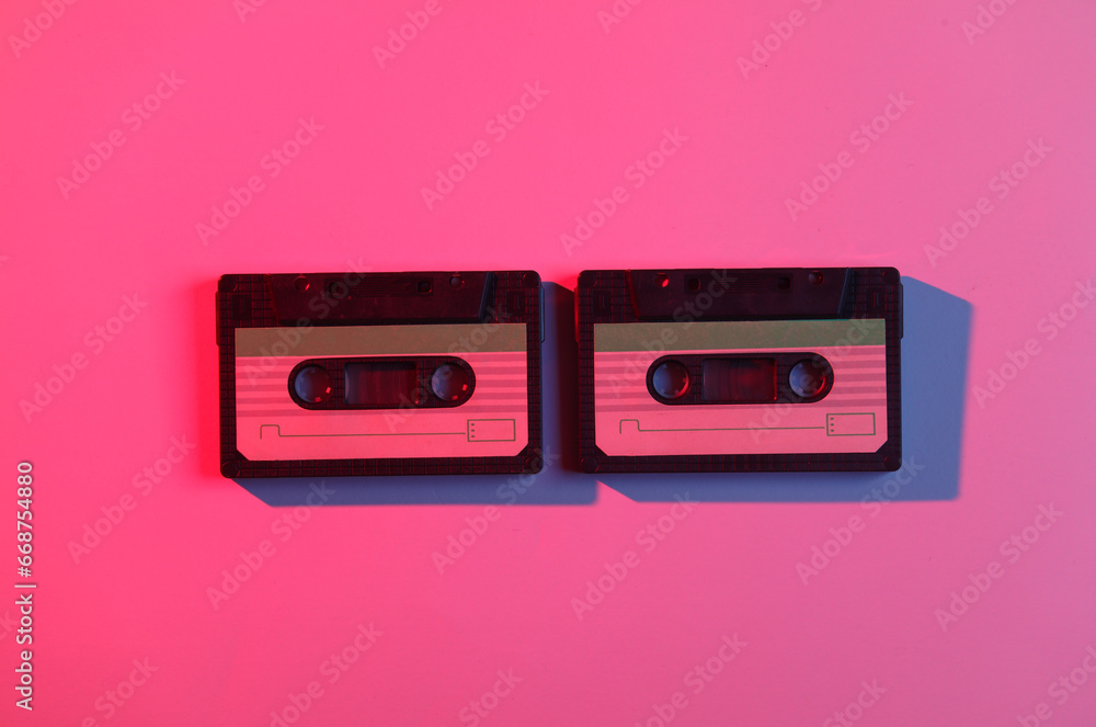 Audio cassettes in neon light. Retro wave, 80s