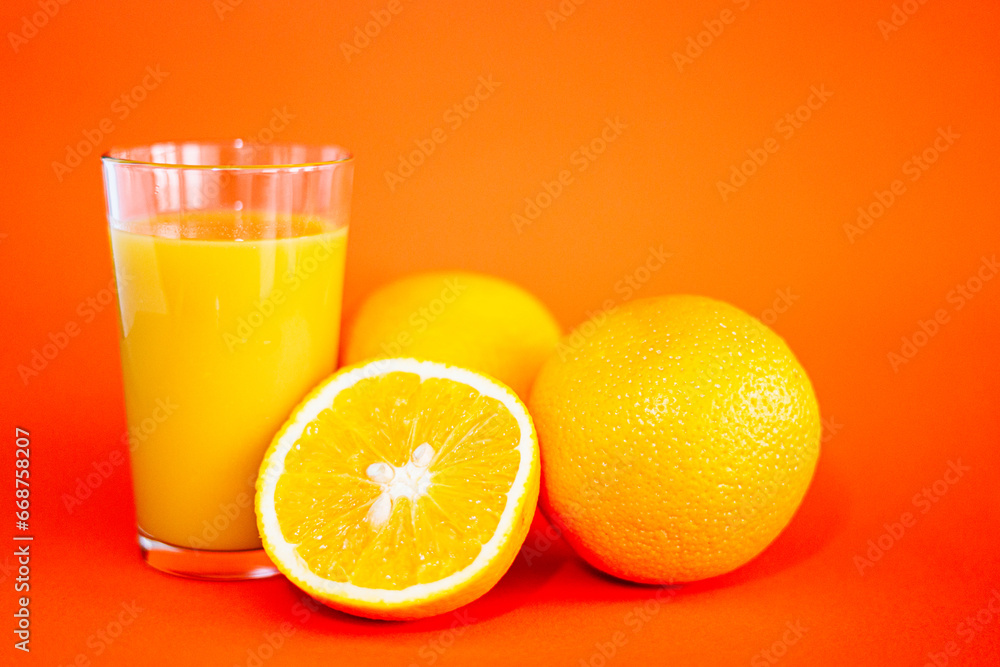 Glas of orange juice wirh oranges and cut open orange with orange background. Glas of orange juice wirh oranges and cut open orange with orange background.