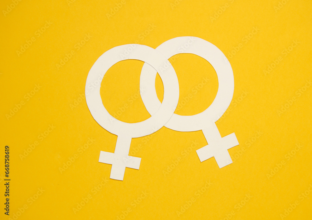 Two female gender venus symbols on yellow background Two female gender venus symbols on yellow background