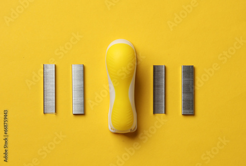 Stapler with bullets starting on yellow background photo