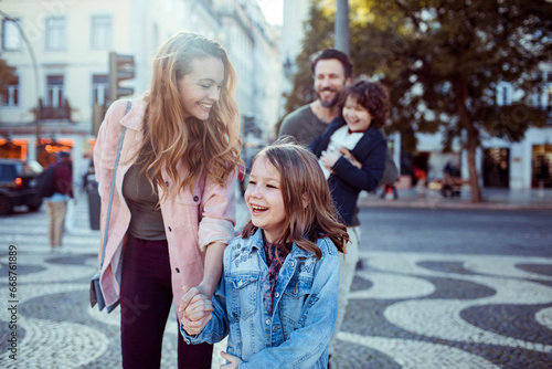 Happy young family exploring the Rossio Square while on vacation in Lisbon