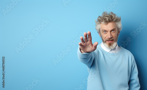 man with hand extended forward gesture with open palm down on light blue background