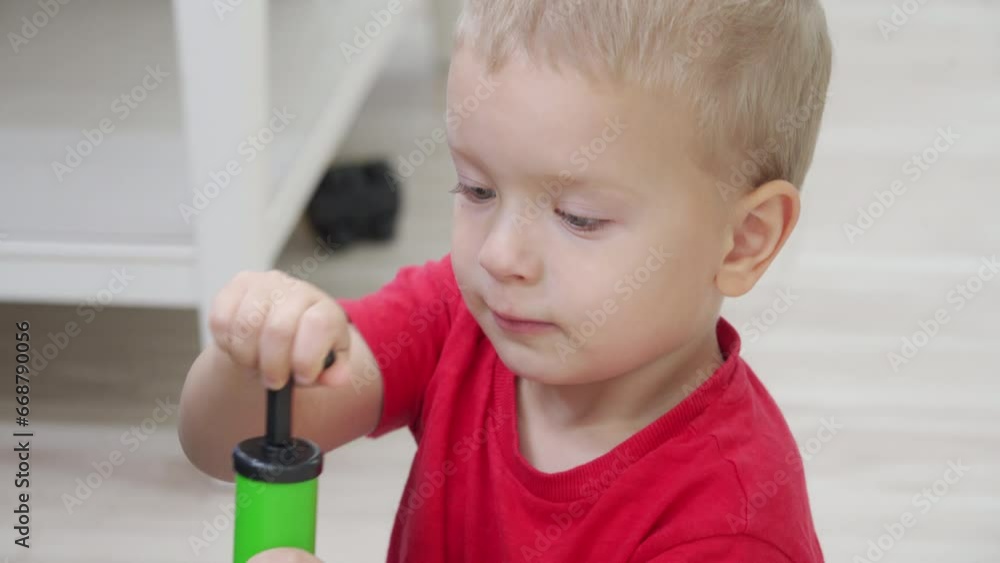 toddler child little boy playing sitting on the floor pumping up a ball at home toddler child little boy playing sitting on the floor pumping up a ball at home