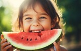 happy child girl is eating a watermelon