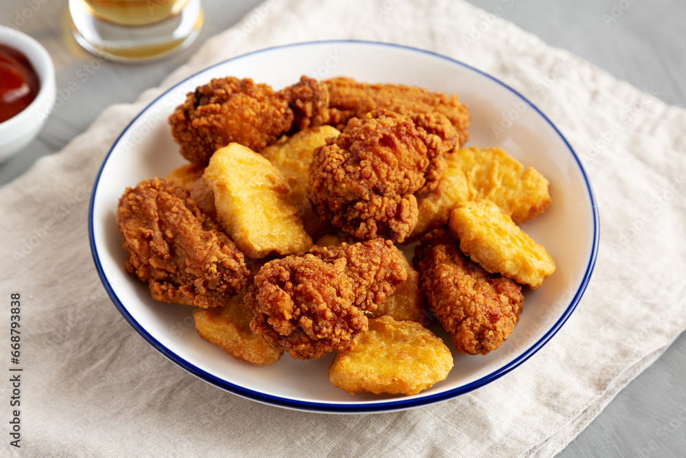 Homemade Chicken Nuggets and Chicken Wings with Ketchup and Beer, side view. Homemade Chicken Nuggets and Chicken Wings with Ketchup and Beer, side view.