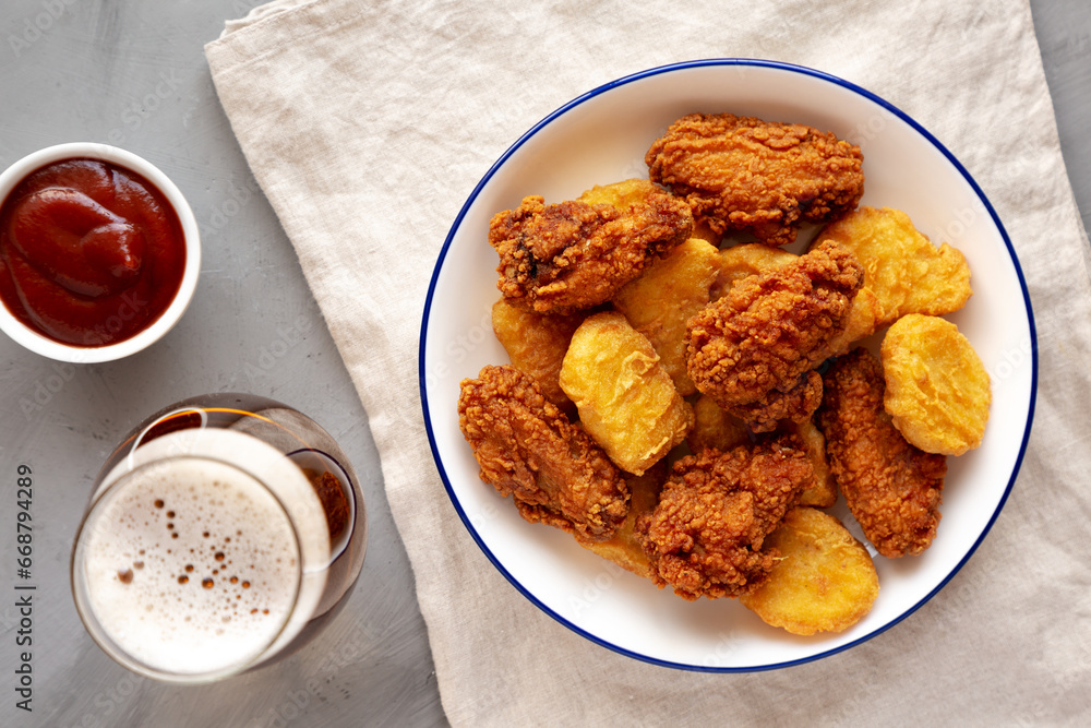 Homemade Chicken Nuggets and Chicken Wings with Ketchup and Beer, top view. Homemade Chicken Nuggets and Chicken Wings with Ketchup and Beer, top view.