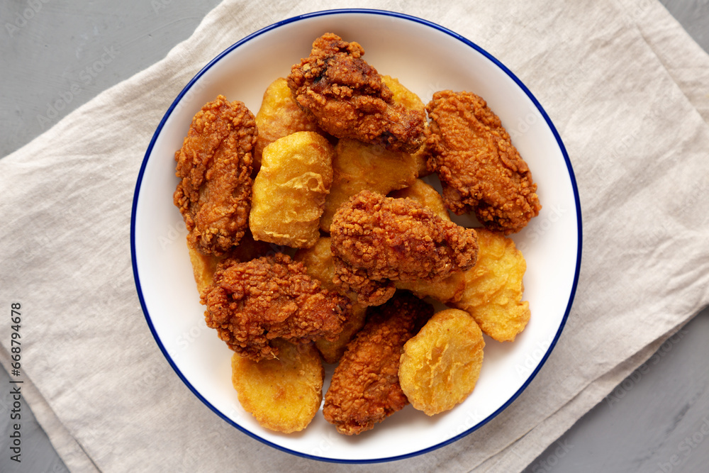Homemade Chicken Nuggets and Chicken Wings on a Plate, top view. Homemade Chicken Nuggets and Chicken Wings on a Plate, top view.