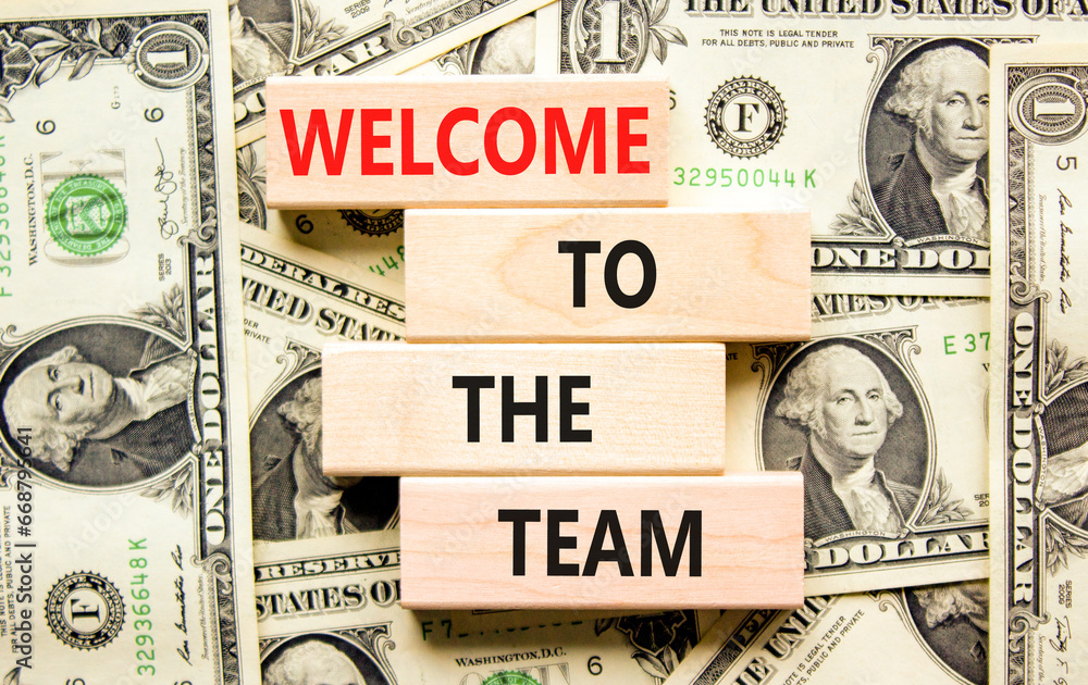 Welcome to the team symbol. Concept words Welcome to the team on wooden block. Dollar bills. Beautiful background from dollar bills. Business, motivational and welcome to the team concept.