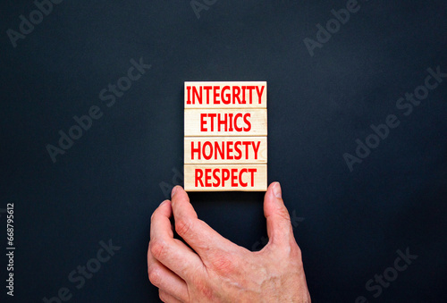 Integrity ethics honesty respect symbol. Concept word Integrity Ethics Honesty Respect on block. Beautiful black background. Businessman hand. Business integrity ethics honesty respect concept.