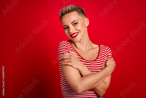 Photo of pretty lovely cute girl wear stylish bright clothes hugging her shoulders empty space isolated on red color background