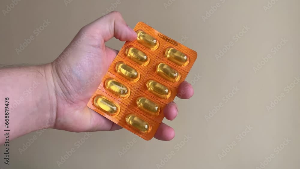 mano con blister de capsulas amarillas