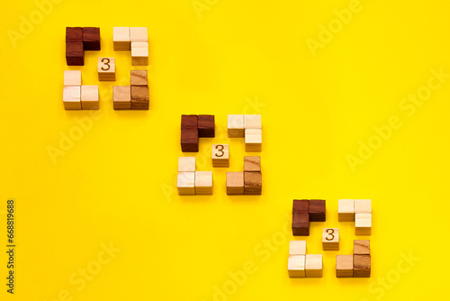 ウッドキューブのフレームに囲まれた3が連続するラッキーな黄色い背景 photo
