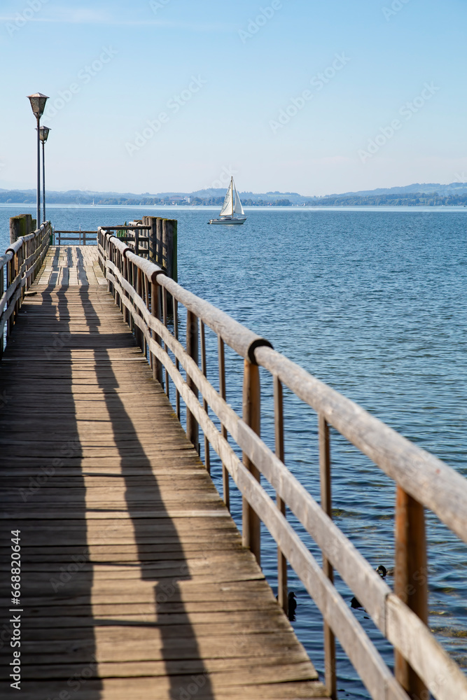 Wooden jetty leading into a lake Chiemsee in the Bavarian Alps