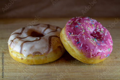 Donuts with chocolate and strawberry filling I put my hand on a wooden stand