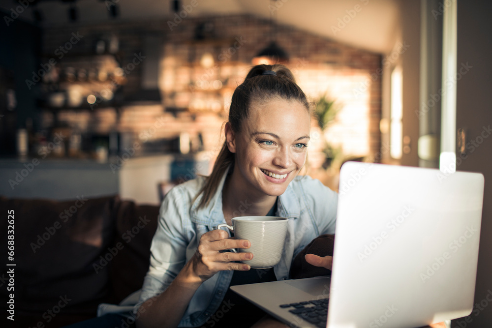 Smiling woman working on her laptop at home Smiling woman working on her laptop at home
